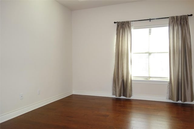 unfurnished room with dark wood-type flooring