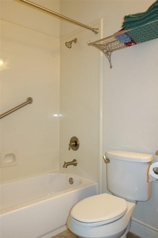 bathroom with toilet and bathtub / shower combination