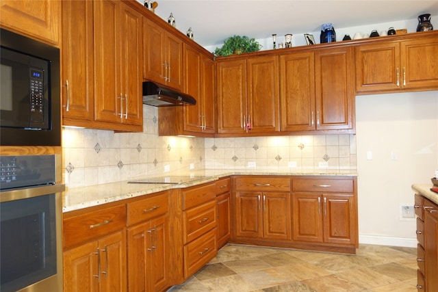 kitchen featuring light stone countertops, backsplash, and black appliances