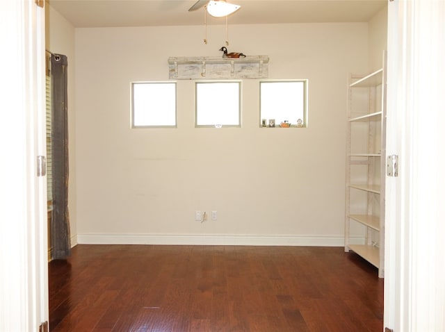 empty room featuring ceiling fan, dark hardwood / wood-style flooring, and a healthy amount of sunlight