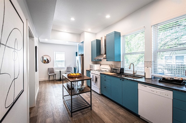 kitchen with dark hardwood / wood-style floors, a healthy amount of sunlight, white appliances, and blue cabinets