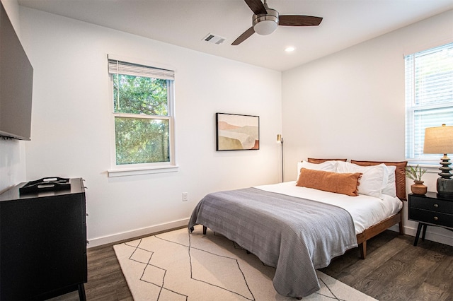 bedroom with dark hardwood / wood-style floors, multiple windows, and ceiling fan