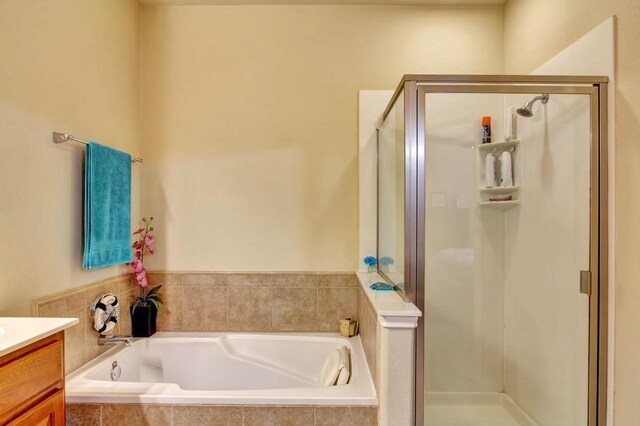 bathroom featuring separate shower and tub and vanity