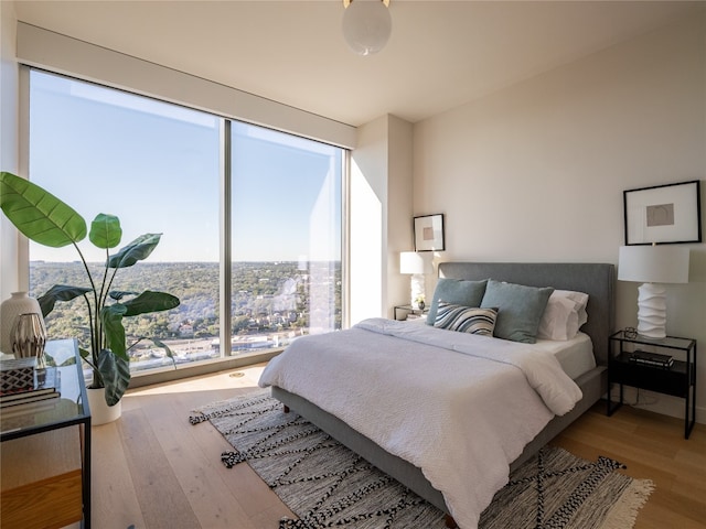 bedroom featuring a city view and wood finished floors