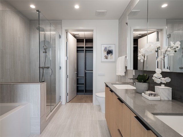 full bath featuring recessed lighting, a sink, a shower stall, decorative backsplash, and double vanity