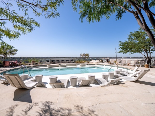 pool with a patio area and a hot tub