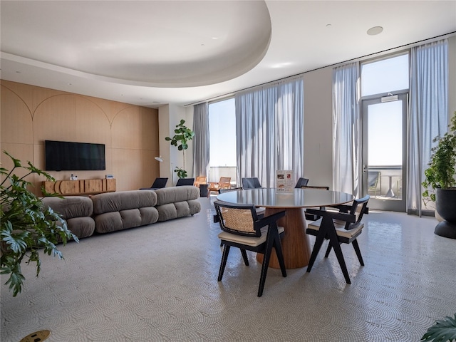 dining area with floor to ceiling windows and a tray ceiling