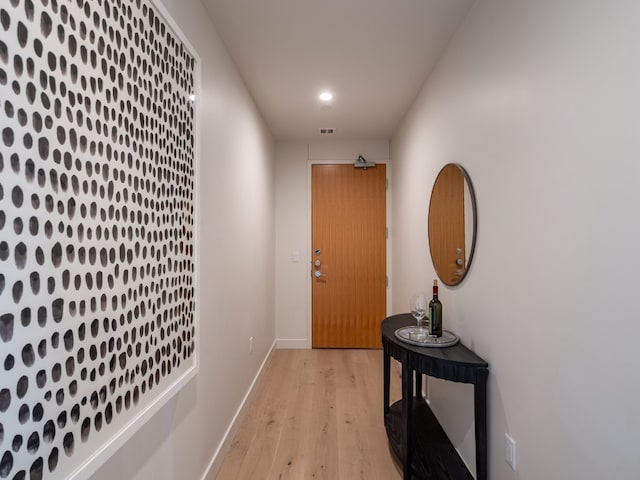 doorway to outside with light wood finished floors, recessed lighting, visible vents, and baseboards