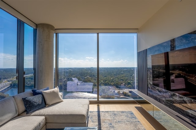 living area featuring a water view, expansive windows, and wood finished floors