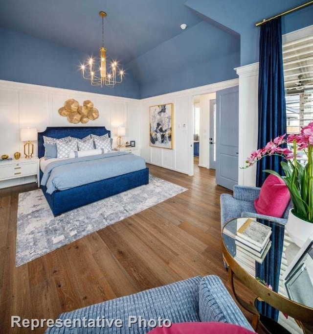 bedroom featuring hardwood / wood-style floors, a chandelier, and vaulted ceiling