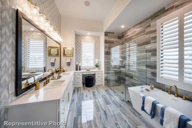 bathroom with shower with separate bathtub, vanity, and tile walls