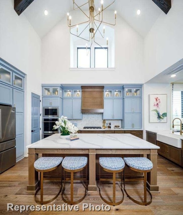 kitchen featuring a spacious island, hanging light fixtures, high vaulted ceiling, and stainless steel appliances