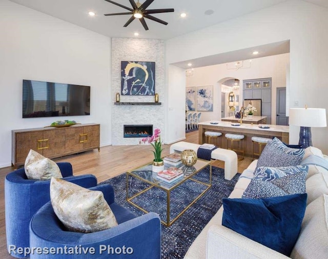 living room with a fireplace, hardwood / wood-style floors, and ceiling fan