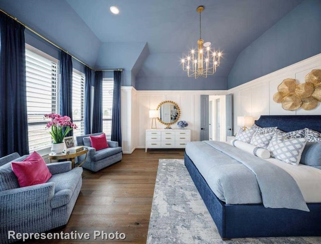 bedroom with hardwood / wood-style floors, lofted ceiling, and an inviting chandelier