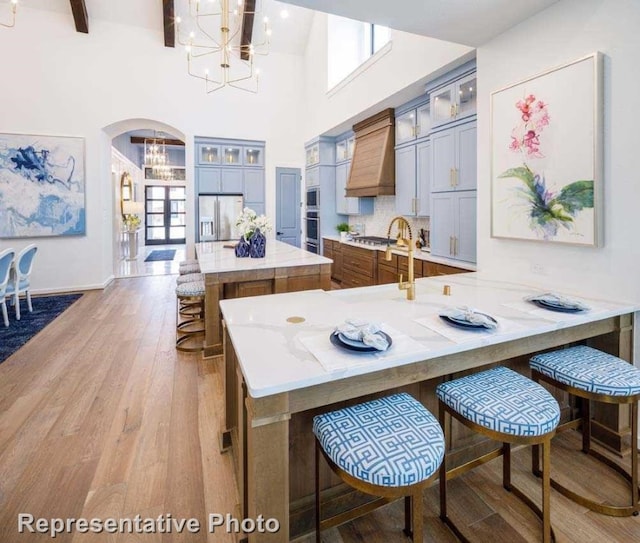 kitchen with kitchen peninsula, a kitchen bar, stainless steel appliances, and light hardwood / wood-style floors