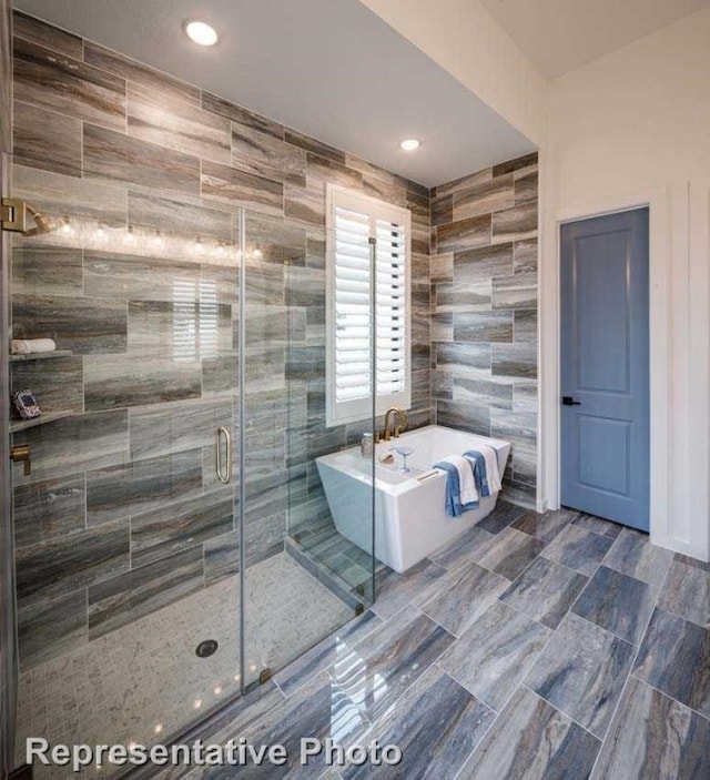 bathroom with separate shower and tub and tile walls