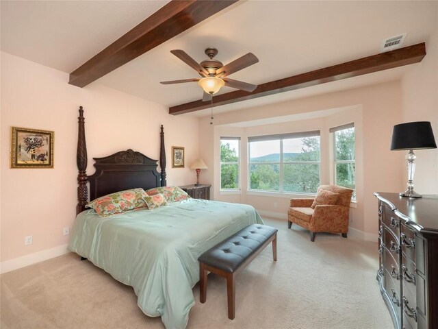 bedroom with ceiling fan, light colored carpet, and beam ceiling