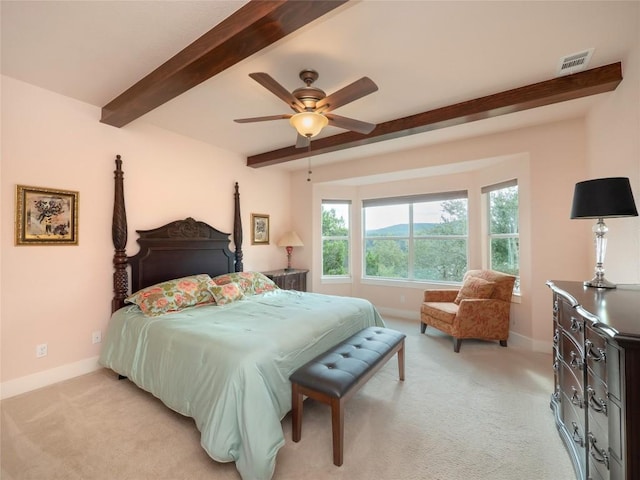 carpeted bedroom featuring beam ceiling and ceiling fan