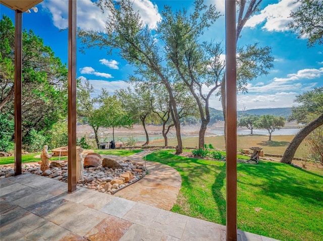 view of yard featuring a water and mountain view and a patio area