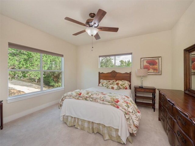 bedroom with ceiling fan and light carpet