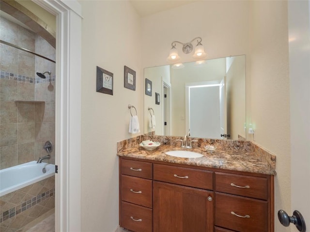 bathroom with tiled shower / bath combo and vanity