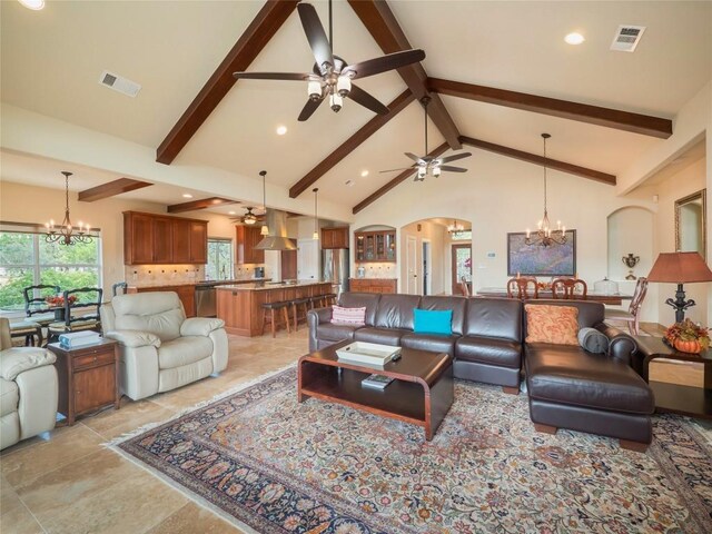 living room with beamed ceiling, ceiling fan with notable chandelier, and high vaulted ceiling