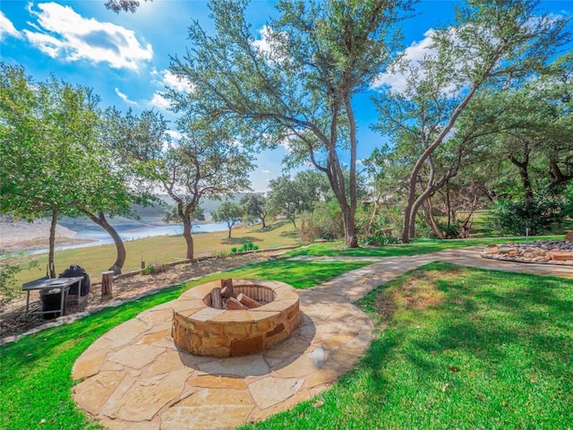 view of yard featuring a water view, a patio area, and a fire pit