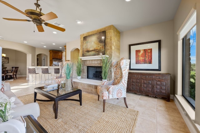 living room featuring ceiling fan, light tile patterned floors, and a fireplace