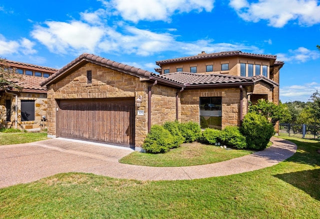 mediterranean / spanish house featuring a garage and a front yard