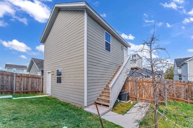 view of side of property with a yard and central AC unit