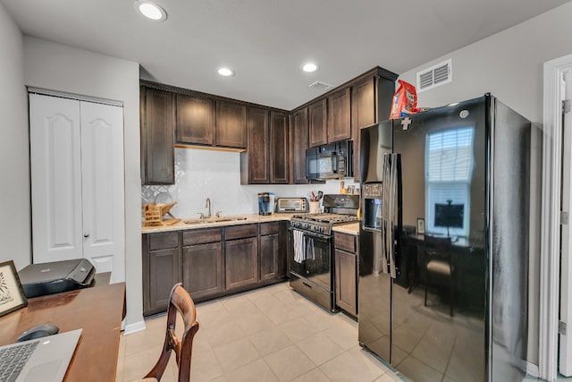 kitchen featuring black appliances, backsplash, dark brown cabinetry, and sink