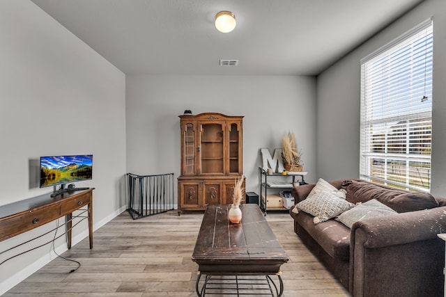 living room with plenty of natural light and light hardwood / wood-style flooring