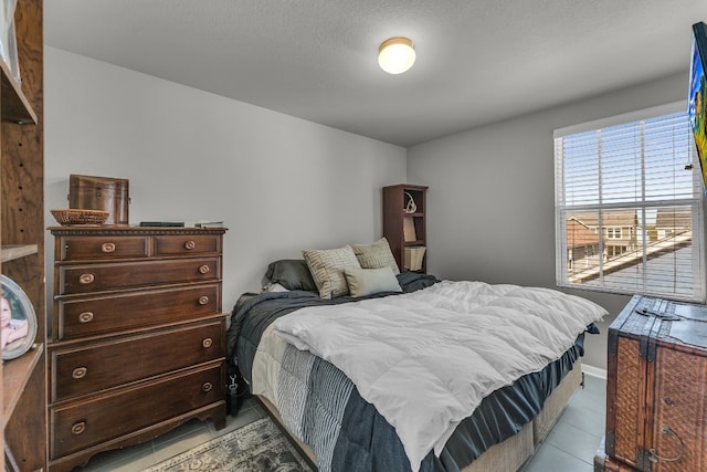 bedroom with a textured ceiling and light tile patterned flooring