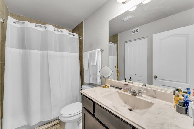 bathroom with walk in shower, vanity, and toilet