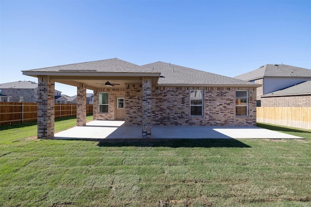 rear view of property with a lawn, ceiling fan, and a patio area