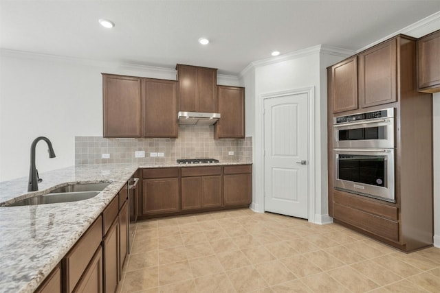 3601 Lapio Way, Round Rock, TX 78665 - kitchen with a sink, appliances with stainless steel finishes, crown molding, tasteful backsplash, and light stone counters