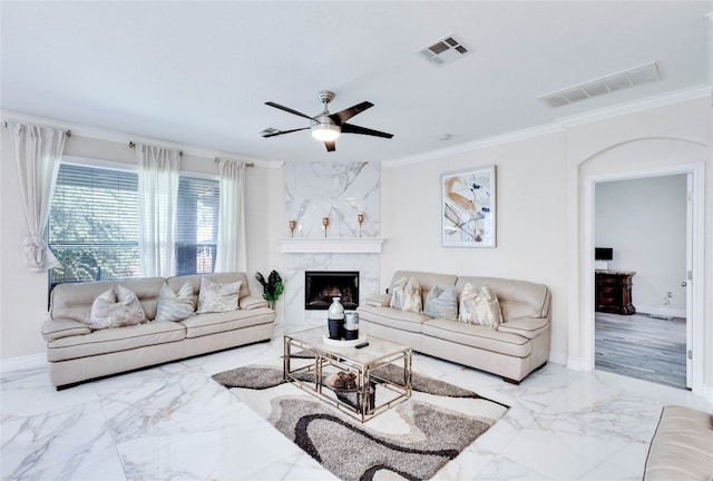 living room featuring a fireplace, ceiling fan, and ornamental molding