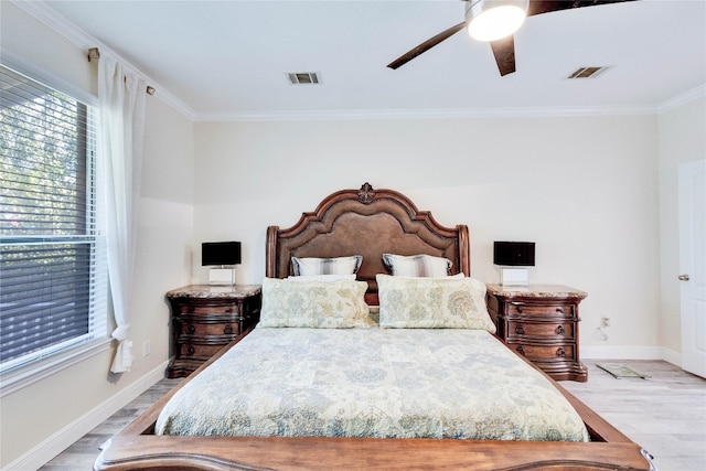 bedroom with light hardwood / wood-style floors, ceiling fan, and ornamental molding