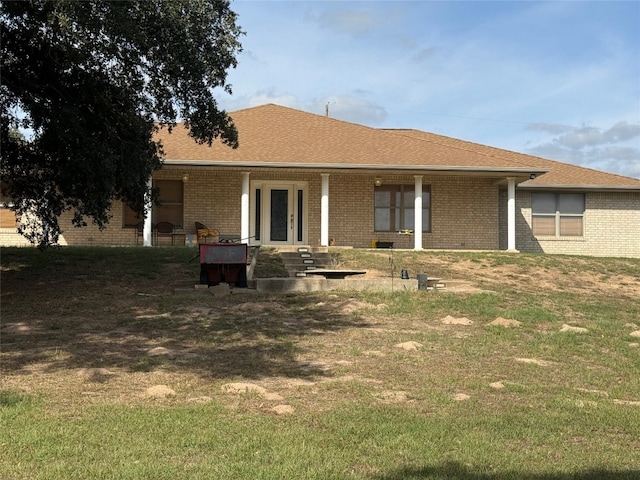 rear view of house featuring a yard