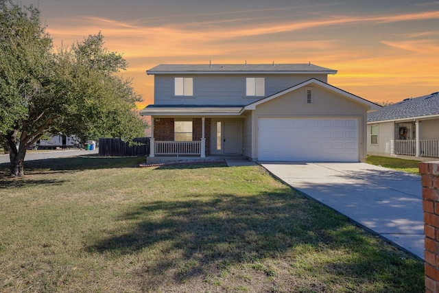 view of property featuring covered porch, a garage, and a lawn