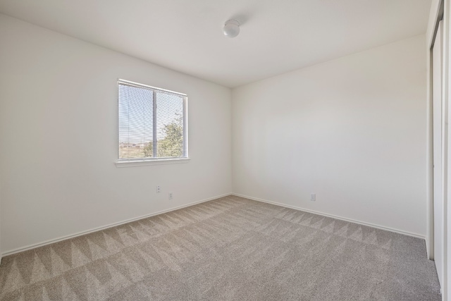 unfurnished room with carpet floors and baseboards