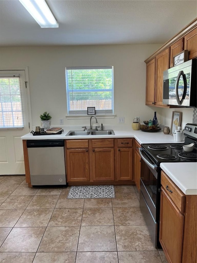 3104 Tyler Ln, Taylor, TX 76574 - kitchen featuring stainless steel appliances, a sink, brown cabinets, and light countertops