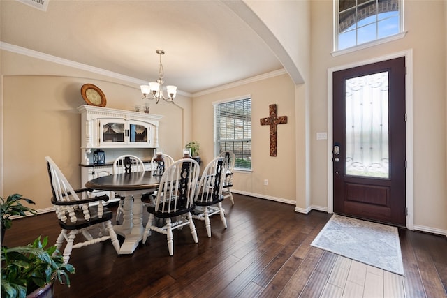 dining room featuring dark hardwood / wood-style floors, an inviting chandelier, and ornamental molding