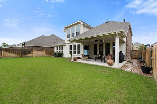 back of property with a patio, ceiling fan, and a lawn