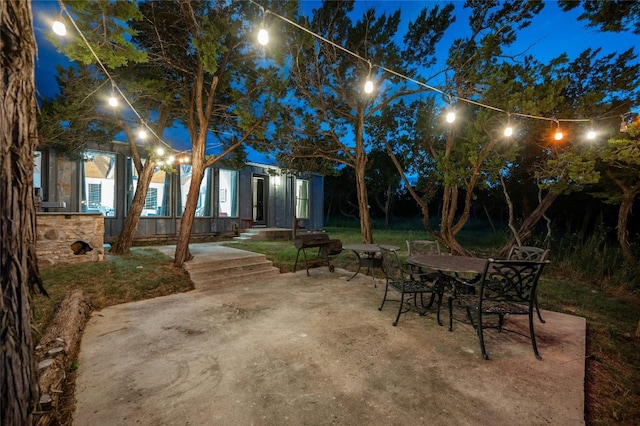 patio at night featuring outdoor dining space