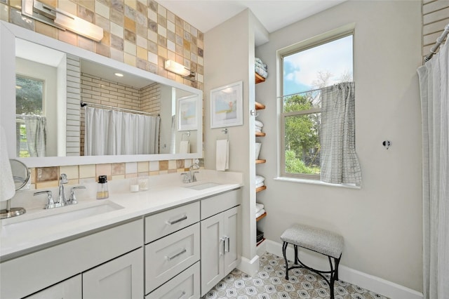 bathroom featuring a wealth of natural light, a sink, and baseboards