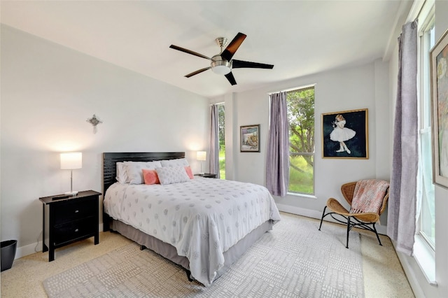 bedroom with ceiling fan, multiple windows, and baseboards