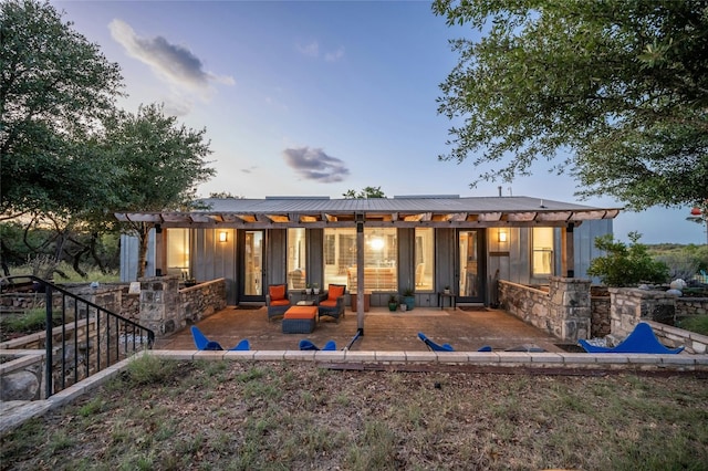 back of property at dusk featuring a patio area