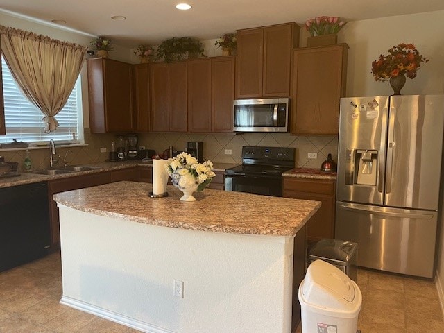 kitchen with a center island, sink, decorative backsplash, appliances with stainless steel finishes, and light tile patterned flooring