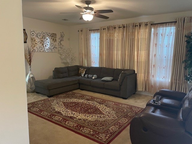 living room featuring carpet flooring, ceiling fan, and a healthy amount of sunlight